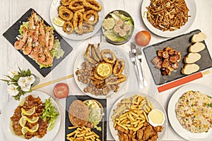 Top view image of Chinese-Spanish fusion dishes with wok stir-fry noodles, tres delicias rice, Andalusian fish fry, grilled photo