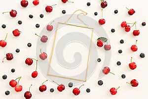 Top view image of colorful assorted mix of berries, blueberry and sweet cherry over wooden white background