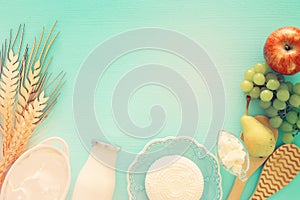 Top view image of dairy products and fruits over wooden background. Symbols of jewish holiday - Shavuot.