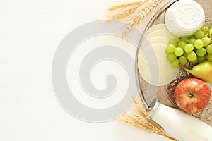 Top view image of dairy products and fruits over wooden background. Symbols of jewish holiday - Shavuot.