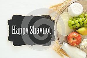 Top view image of dairy products and fruits on wooden background. Symbols of jewish holiday - Shavuot.
