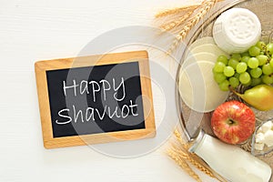 Top view image of dairy products and fruits on wooden background. Symbols of jewish holiday - Shavuot.