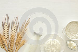 Top view image of dairy products over white wooden background. Symbols of jewish holiday - Shavuot.