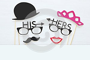 Top view image of funny photo booth props with text: HIS, HERS for party or wedding over white background.