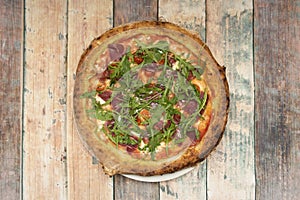 Top view image of Iberian ham pizza with arugula and mozzarella cheese
