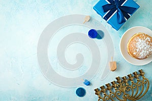 Top view image for jewish holiday Hanukkah with traditional donuts, menorah and gift box