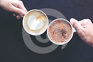 Top view image of man and woman`s hands holding coffee and hot chocolate cups