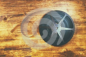 Top view image of old 8 mm movie reel over wooden background
