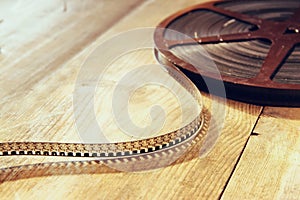 Top view image of old 8 mm movie reel over wooden background