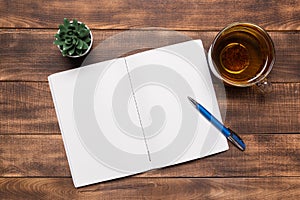 top view open notebook with blank pages next to cup of coffee on wooden table. ready for adding text or mockup