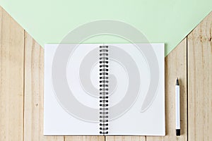 Top view image of open notebook with blank pages on wooden background, ready for adding or mock up
