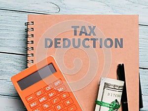 Top view image phrase tax deduction on the notebook with a pen on the table.