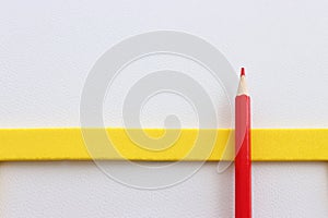 Top view image of red pencil on white textured paper