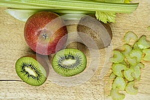 Top view image of ripe green kiwis, red apple and celery chopped to make a detox juice