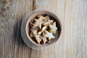 Top view image of small biscuits in many shapes in wooden cup