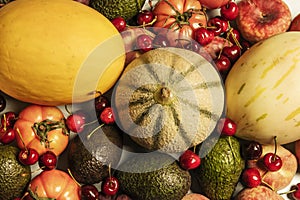 Top view image of a still life with ripe melons, picota cherries, various tomatoes, Canarian bananas