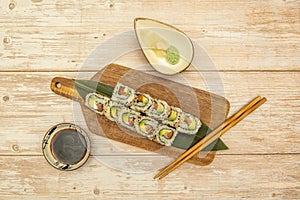 Top view image of uramaki california roll sushi with sesame seeds, nori seaweed, cream cheese, salmon and ripe avocado