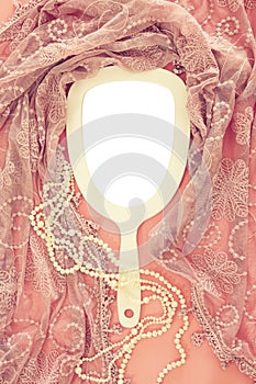 Top view image of vintage hand mirror and delicate female romantic scarf