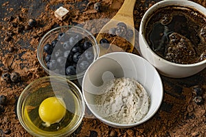 top view of ingredients for cooking or baking chocolate on the table, blueberry, egg, flour, cocoa and chocolates