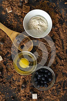 top view of ingredients for cooking or baking chocolate on the table, blueberry, egg, flour, cocoa and chocolates