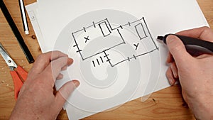 Top view, an interior designer`s hand draws an ideal map for a new home, footage ideal for topics such as building