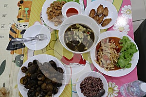 Top view, Isaan Thai food, mushroom curry, fried chicken and papaya salad, a popular local dish.