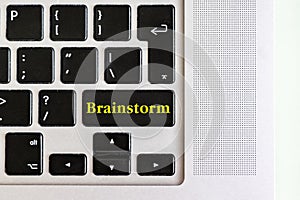 Top view isolated laptop keyboard with yellow `brainstorm` text on button, concept design f