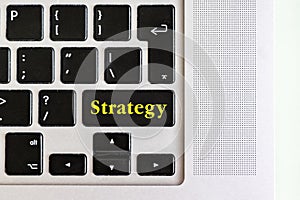 Top view isolated laptop keyboard with yellow `strategy` text on button, concept design f