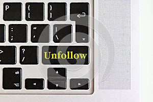 Top view isolated laptop keyboard with yellow `unfollow` text on button, concept design f