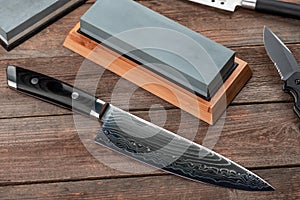 Top view on a Japanese Gyuto knife, a jackknife and a whetstone
