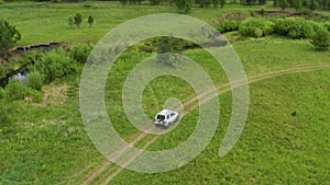 Top view of a jeep driving on a dirt road in nature