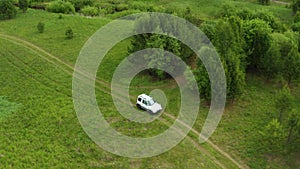 Top view of a jeep driving on a dirt road in nature