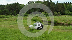 Top view of a jeep driving on a dirt road in nature