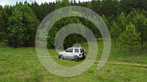 Top view of a jeep driving on a dirt road in nature