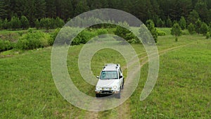 Top view of a jeep driving on a dirt road in nature