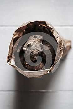 Top view of Jerusalem artichokes in a brown bag with a blurred background