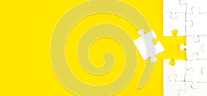 jigsaw puzzle with one piece left on yellow background