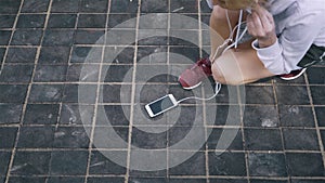 Top view of a jogger woman tying her shoelace and starting to run