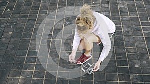 Top view of a jogger woman tying her shoelace and starting to run outside