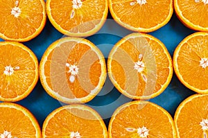 Top view of juicy fruit halves orange located on a blue background