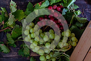 Top view of the juicy and ripe green and red grapes on the wooden surface
