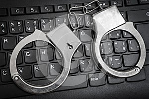 Top view of keyboard and handcuffs - cyber crime concept