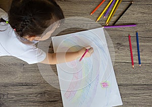 Top view of kid drawing with color pencil