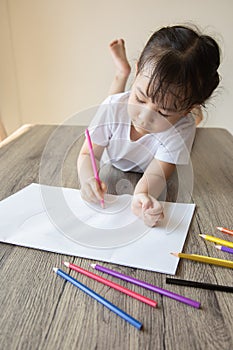 Top view of kid drawing with color pencil