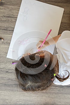 Top view of kid drawing with color pencil