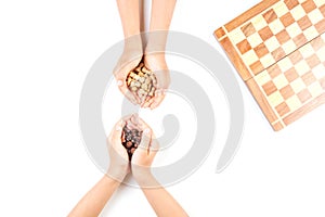 Top view of kid hand and chess board with chess pieces