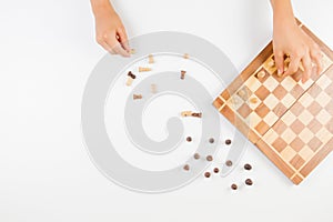 Top view of kid hand and chess board with chess pieces