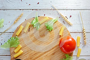 Top view of kitchen board with raw ingredients of italian tortiglioni pasta.