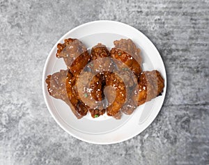 Top view Korean spicy deep-fried chicken topped white sesame on the gray concrete table, popular street food in Korea