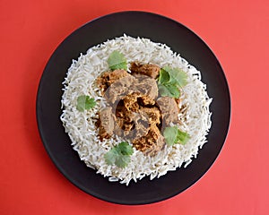 A top view of lamb korma with basmati rice and coriander leaves photo